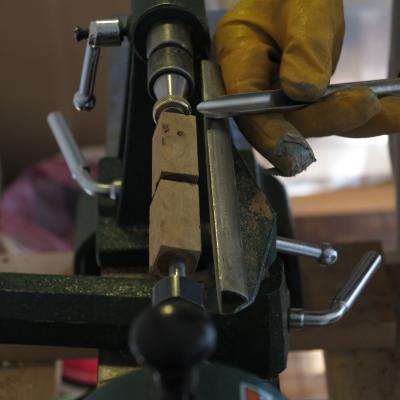 Blocchetto di legno grezzo montato sul tornio per la realizzazione di una penna